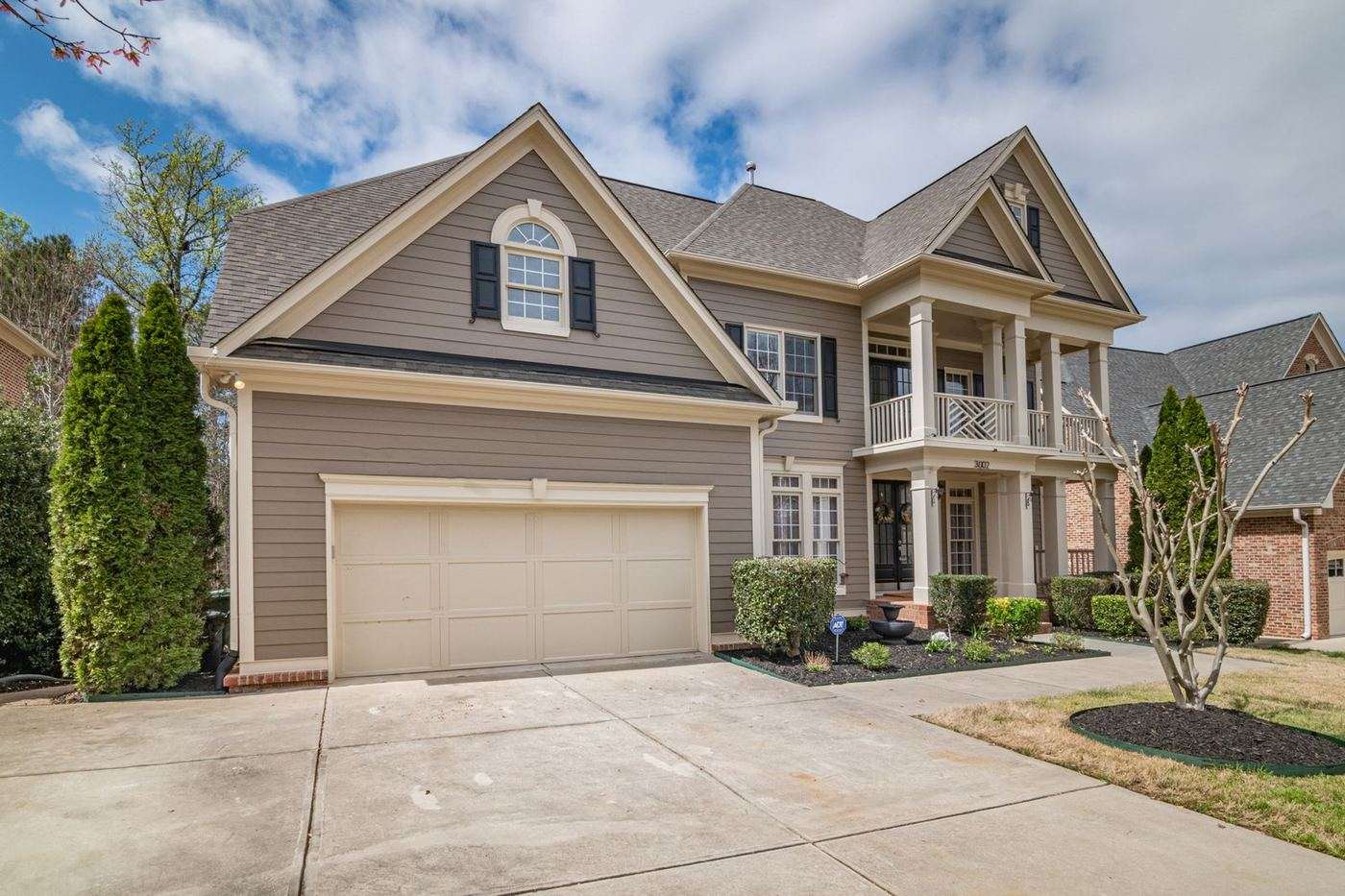 Cream carriage-house style garage door with decorative hardware on a craftsman home