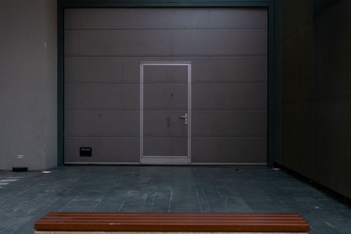 Flat dark gray flush-panel garage door with a matching pedestrian door beside it