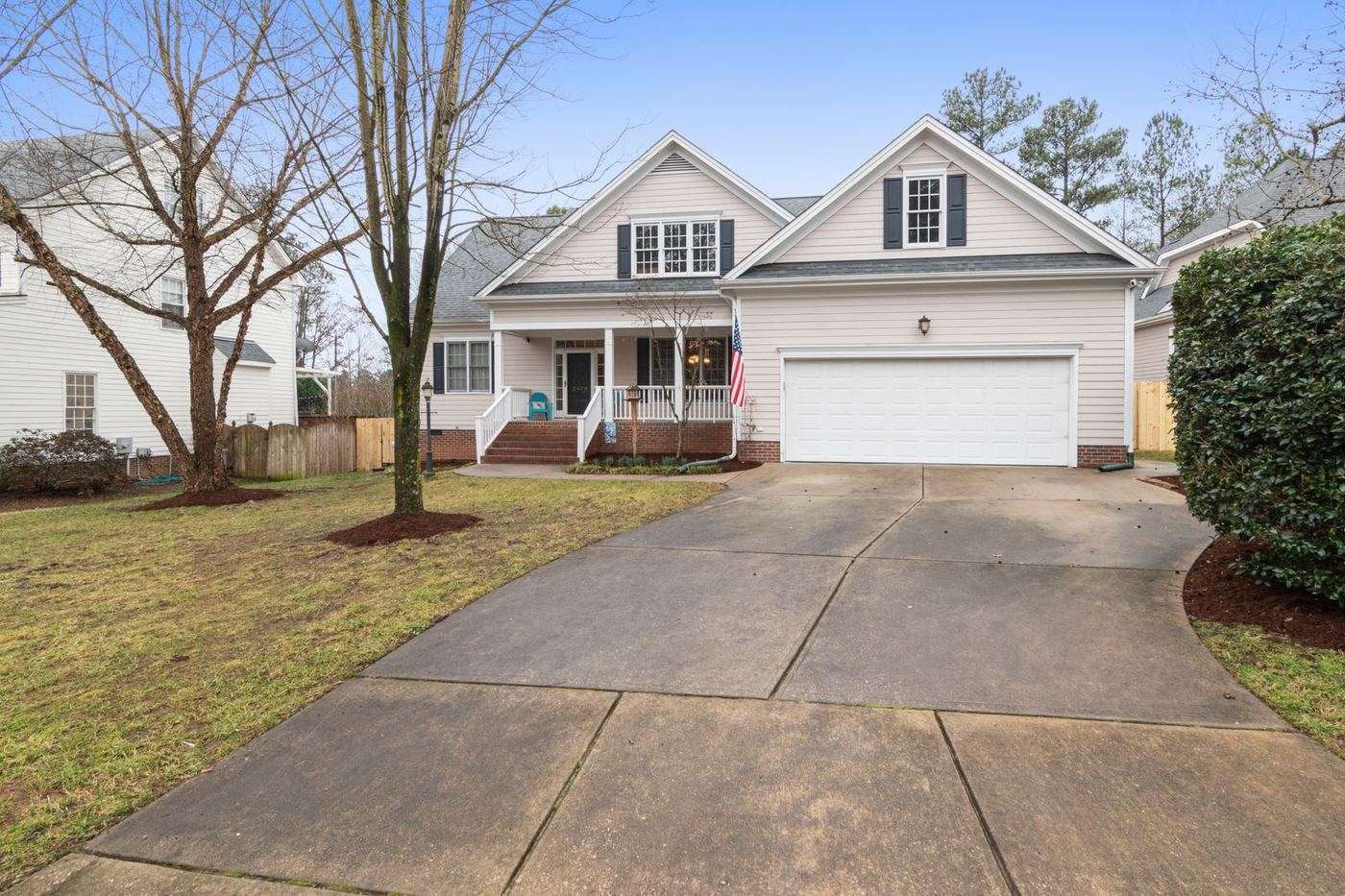 White raised-panel steel garage door on a two-story American colonial home