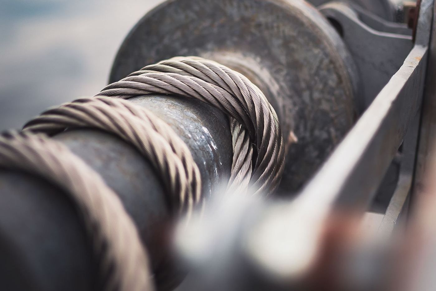 Braided steel lift cable wound around a grooved metal drum