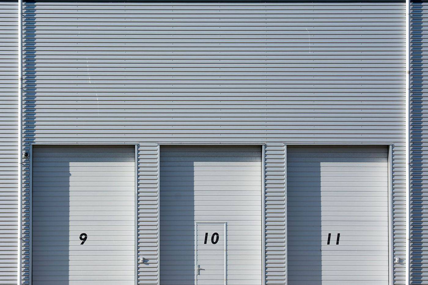 Metal sectional doors seated in their vertical side tracks along a building wall