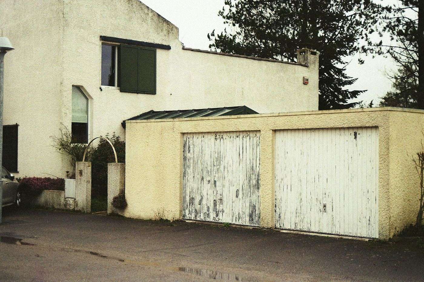 Weathered garage door panels with peeling paint and visible damage along the bottom section