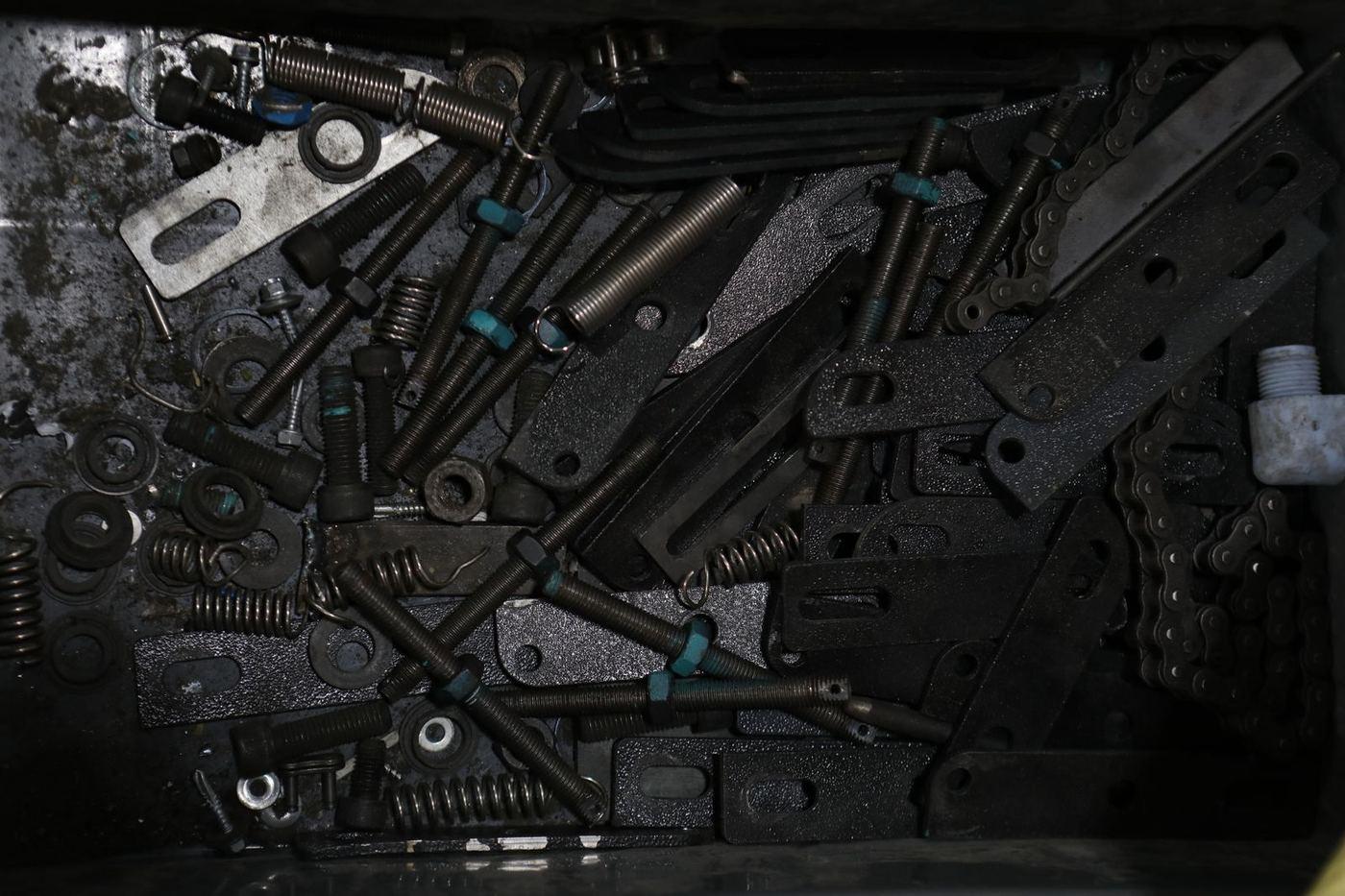 Assorted steel garage door hardware including springs, hinges and small fixings