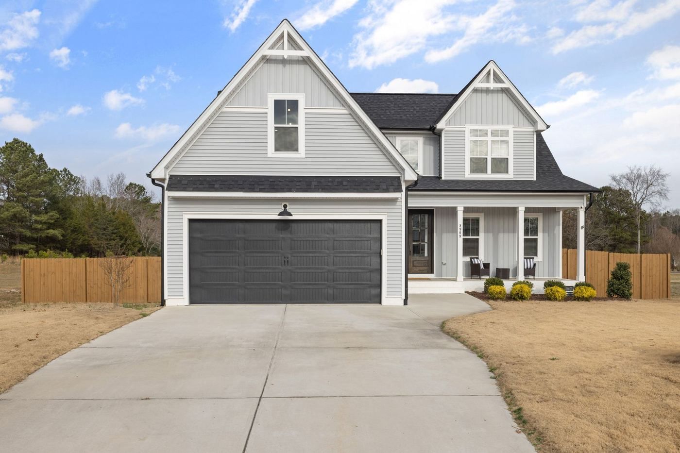 Gray two-story Waco home with a dark modern double garage door facing a wide concrete driveway