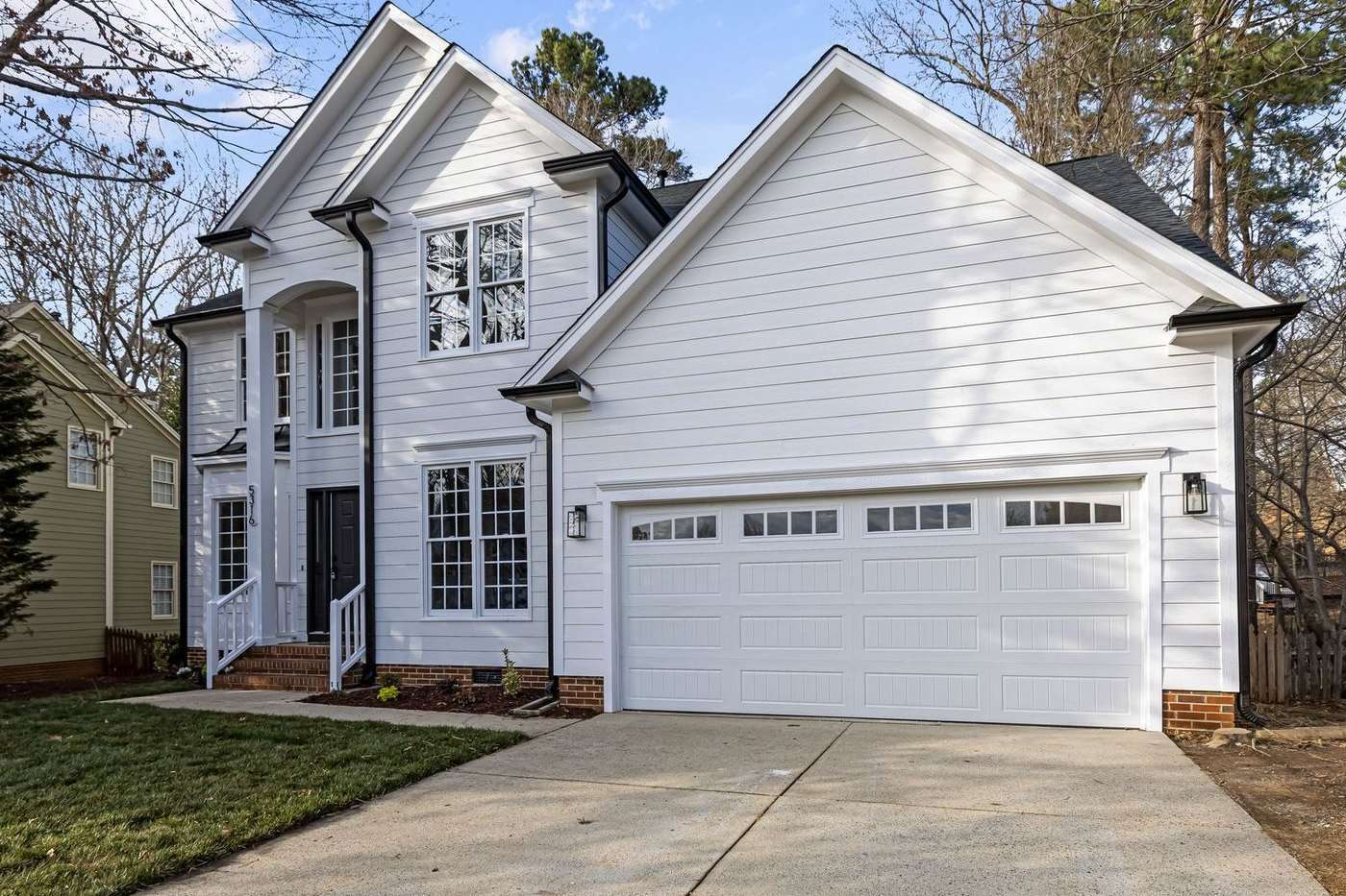 White single-story Bellmead home with a white garage door and a long straight driveway