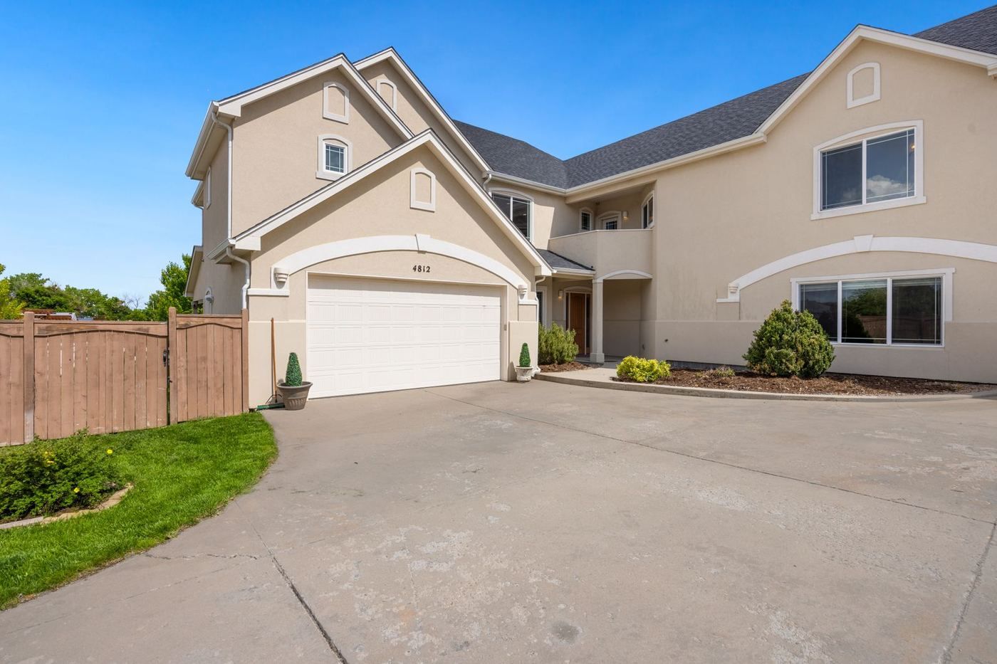 Two-story Lorena home with a white double garage door at the end of a curving driveway